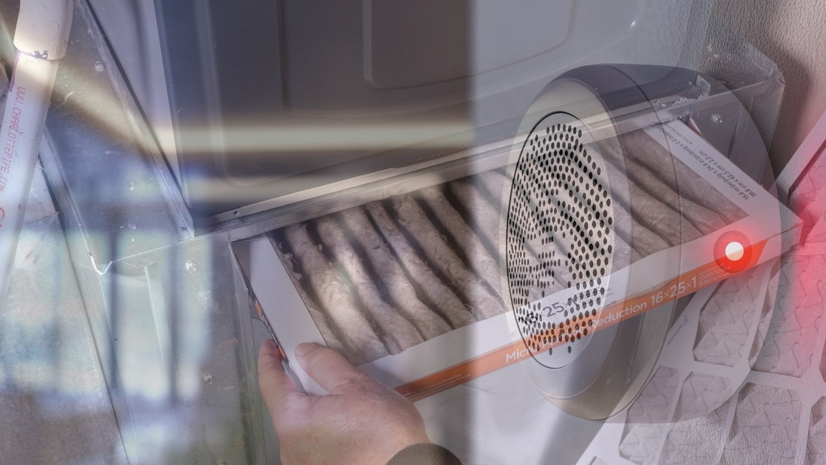 Hand pulling a furnace filter with a red warning light