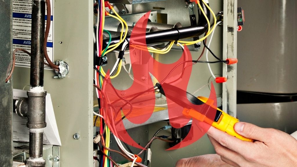 Technician testing furnace wiring with a voltage tester